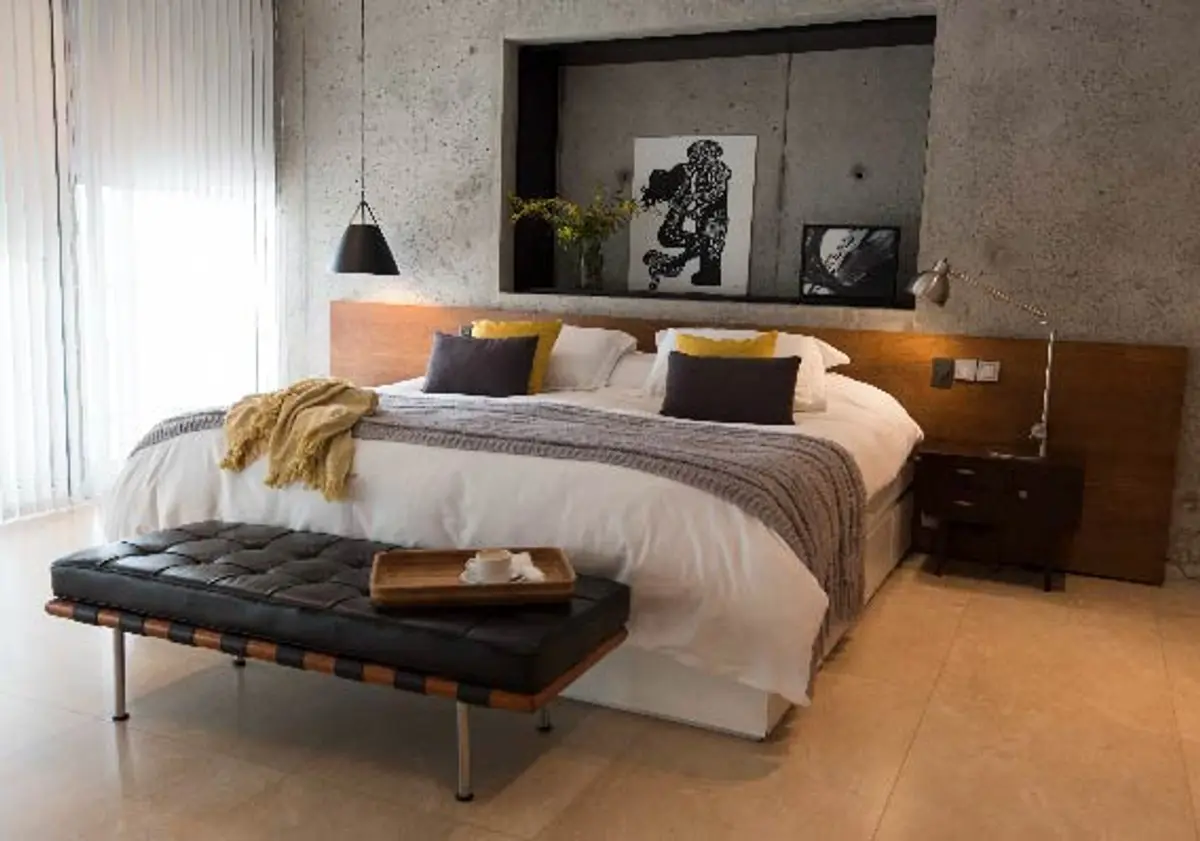 dormitorio moderno con paredes de concreto y cama grande — proyecto CASA GOLF III, por Alejandra Pan Arquitectura, en Nordelta