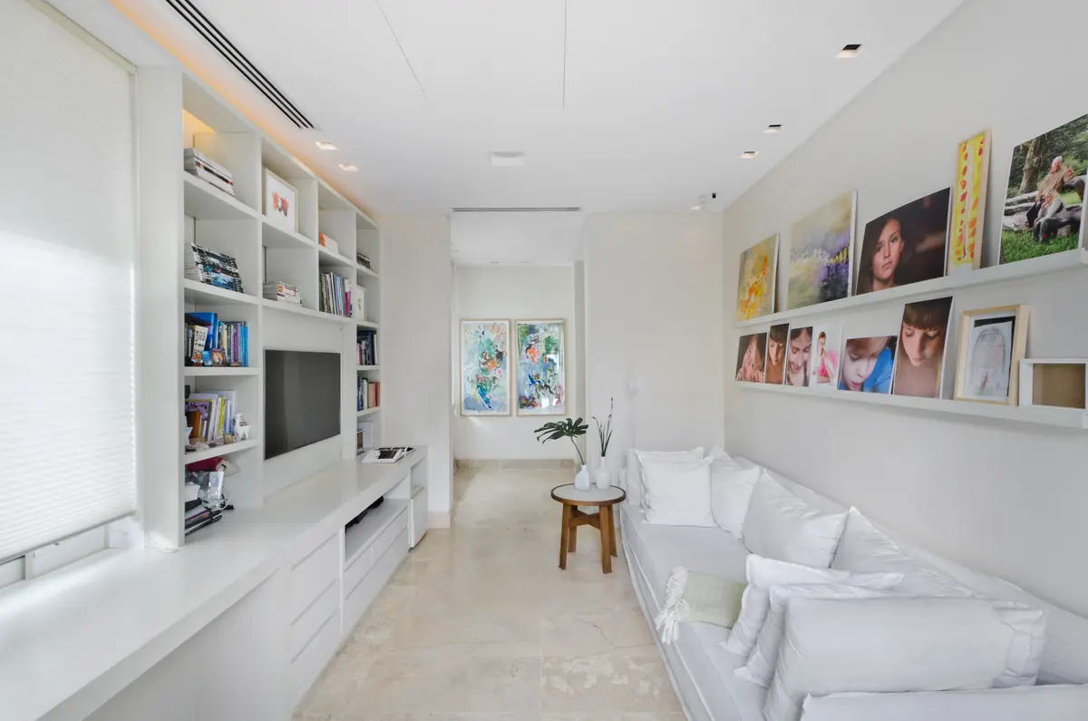 Sala de estar moderna com estante embutida e sofá branco — projeto Casa H, por Estudio Dado, em Belgrano