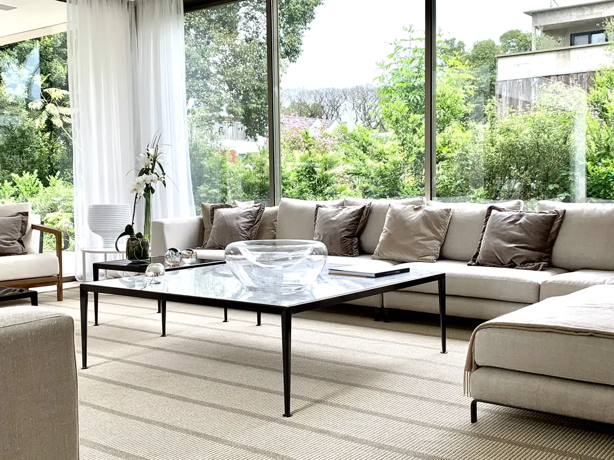 Sala de estar moderna com janelas amplas para a floresta e sofá modular cinza — projeto CASA BECCAR, por Estudio Xime Fontan Balestra, em Béccar