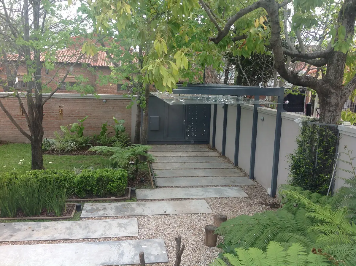 Fachada moderna con pérgola de madera y mucha vegetación — proyecto Obra Martínez, por M. Beatriz Gonzalez Zuelgaray, en Martínez