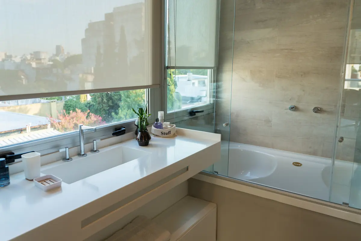 Banheiro moderno com janela grande e banheira de imersão — projeto Departamento Nuñez, por Estudio CDW, em Núñez