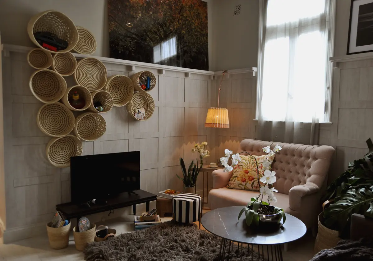 Living acogedor con sillón beige y pared de mimbre bohemio — proyecto Casa FOA Espacio Cabrera, por Marconi Silva Arquitectos, en CABA