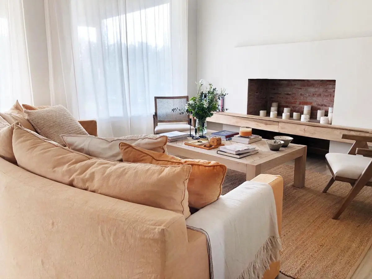 Sala de estar moderna e iluminada com lareira e sofá grande — projeto CASTAÑOS, NORDELTA, por Greschek Obras, em Nordelta