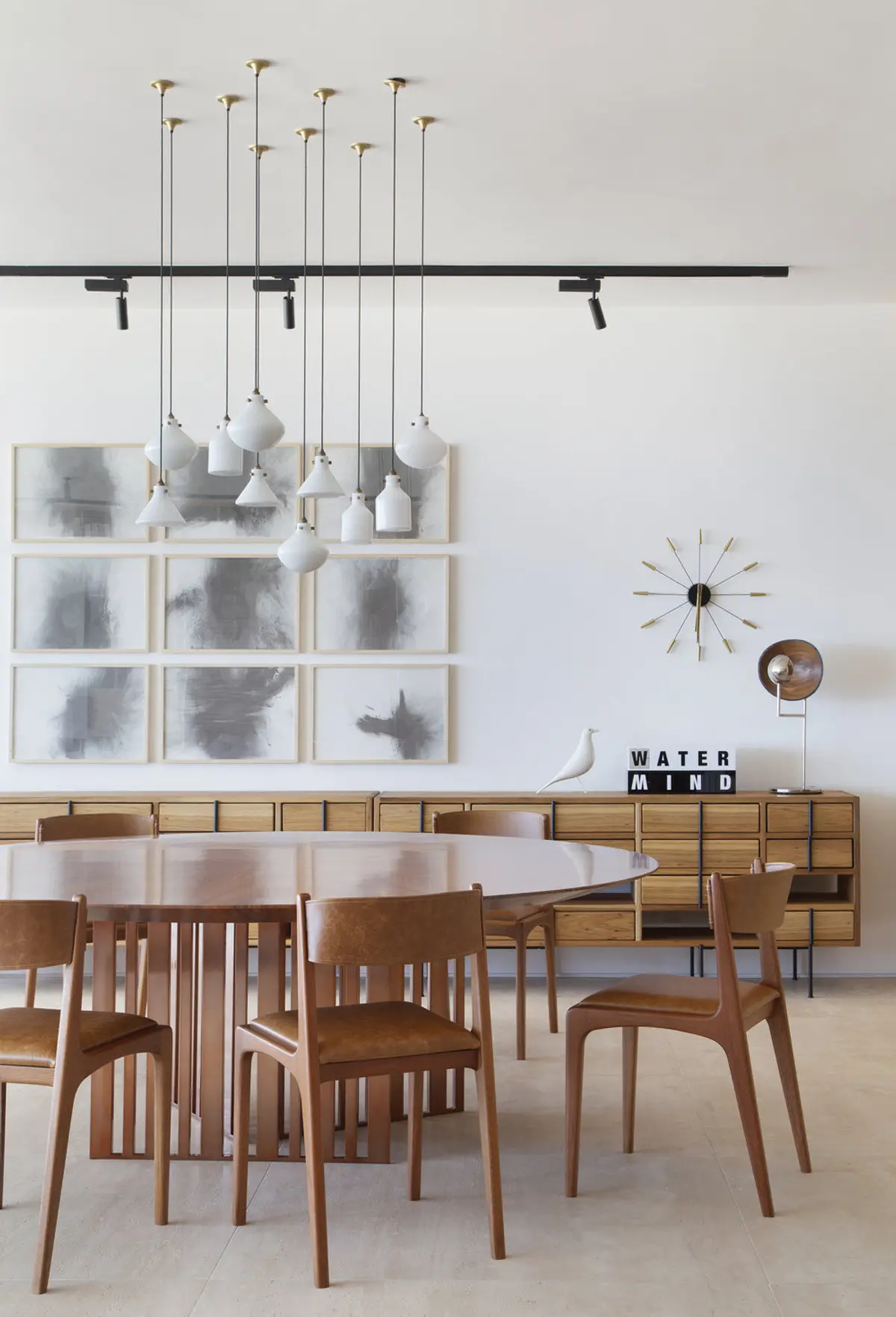 Comedor minimalista con mesa redonda, sillas de madera y lámparas colgantes — proyecto PS House, por Studio Ro-ca