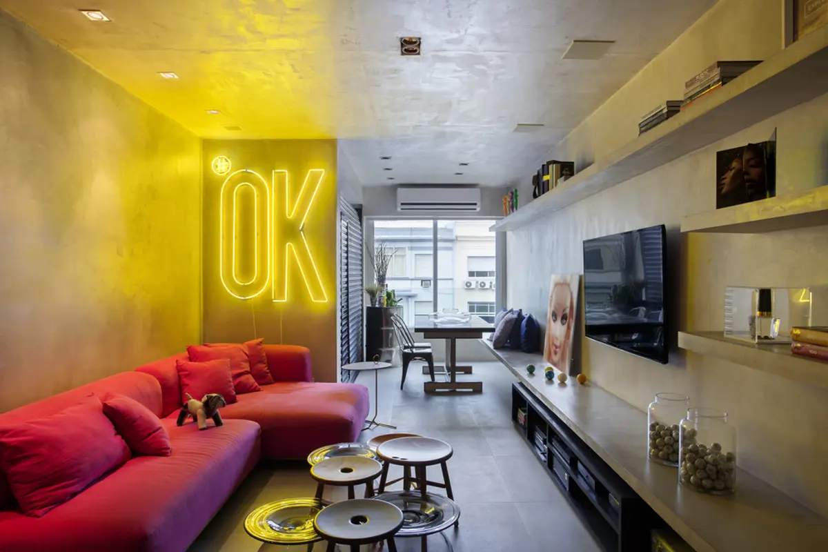 Living moderno con sofa rojo neón y señal OK amarillo — proyecto MM House, por Studio Ro-ca