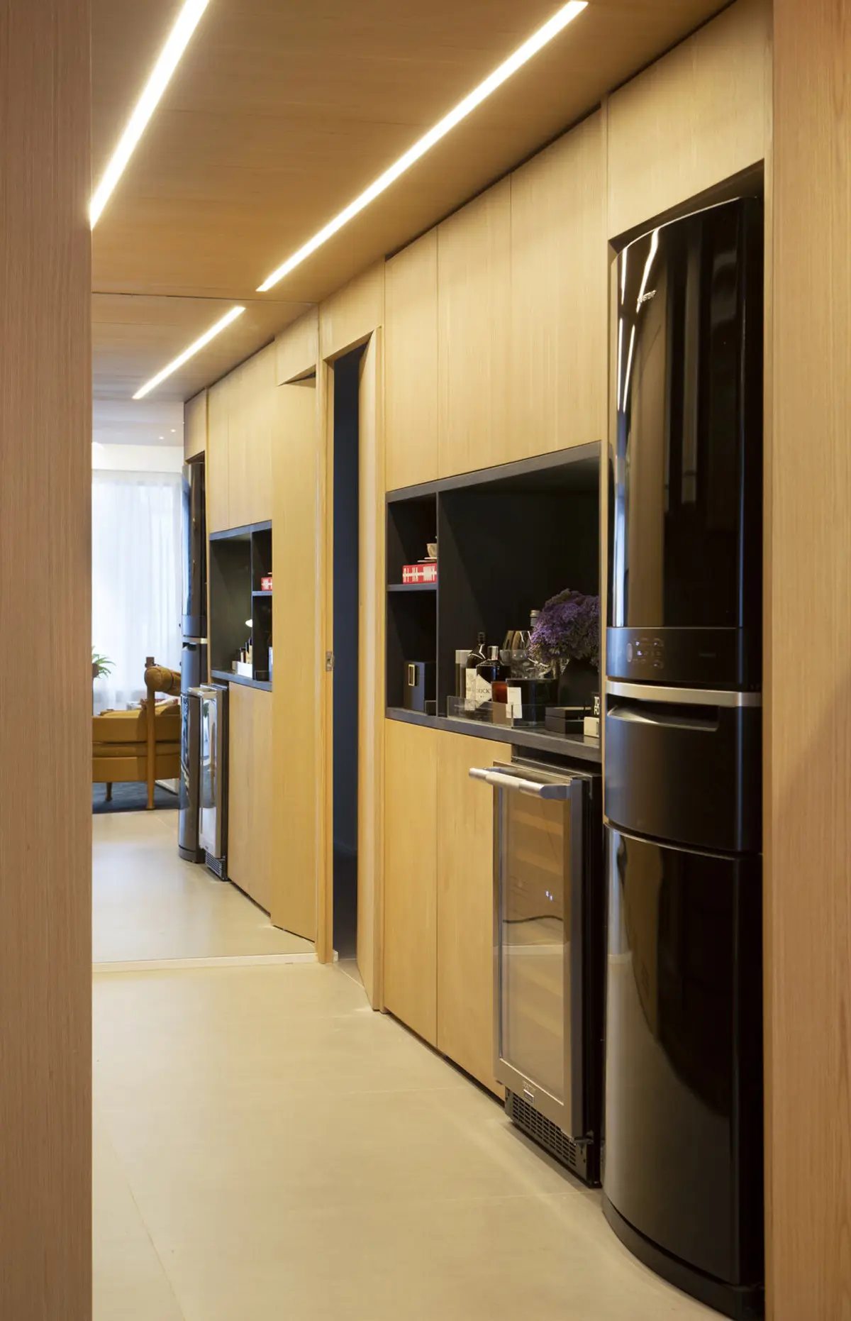 Pasillo moderno con iluminación lineal y cocina integrada con electrodomésticos negros — proyecto MN House, por Studio Ro-ca