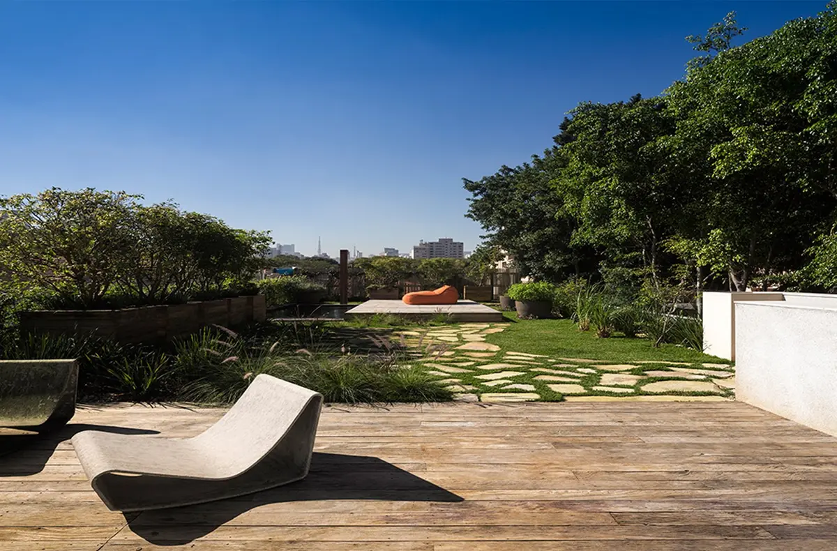 Terraza de madera con lounge chair y jardin verde moderno — proyecto Residência AC, por Gil Fialho