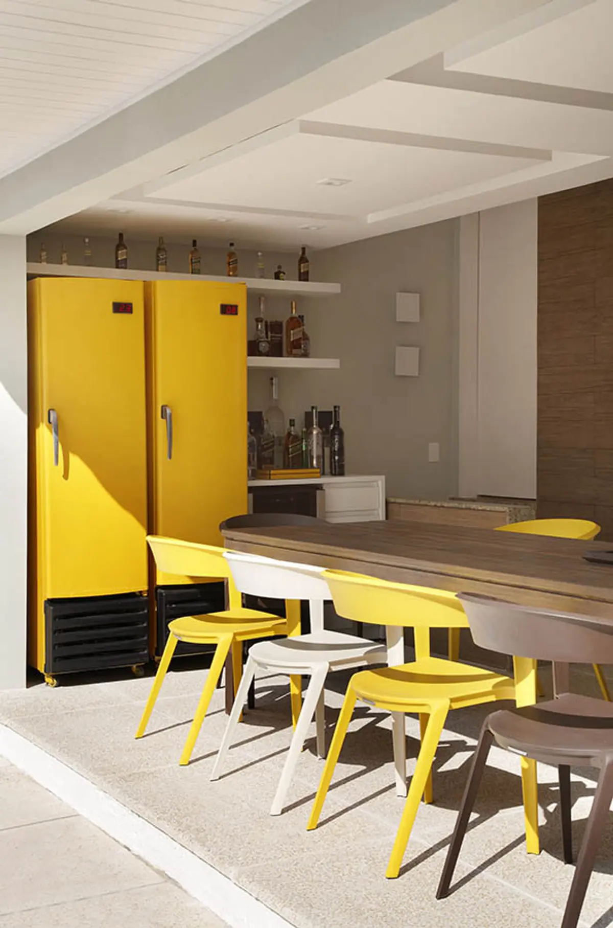 Comedor moderno con heladeras amarillas y sillas de diseño — proyecto Casa Barra ED, por Amanda Miranda