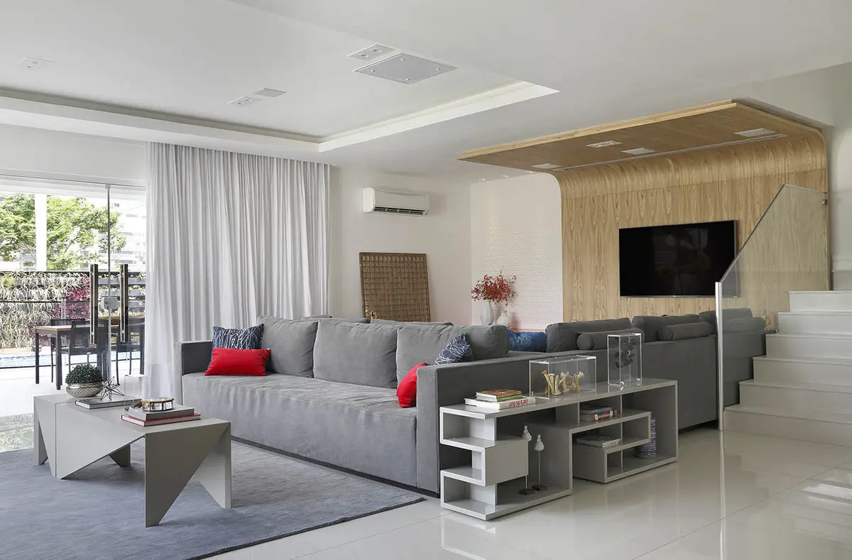 living moderno con sofá gris, TV empotrada y balcón luminoso — proyecto Casa Blue House, por Amanda Miranda