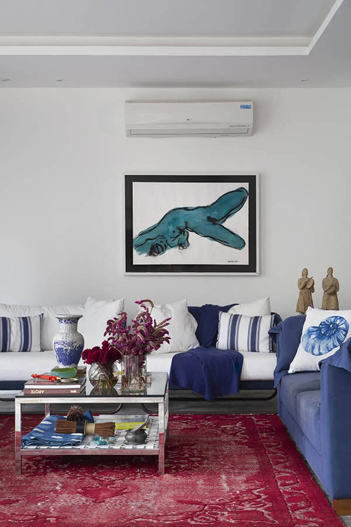 Living moderno con sofá azul, cuadro de ballena y aire acondicionado — proyecto Casa Jardim Guanabara, por Amanda Miranda