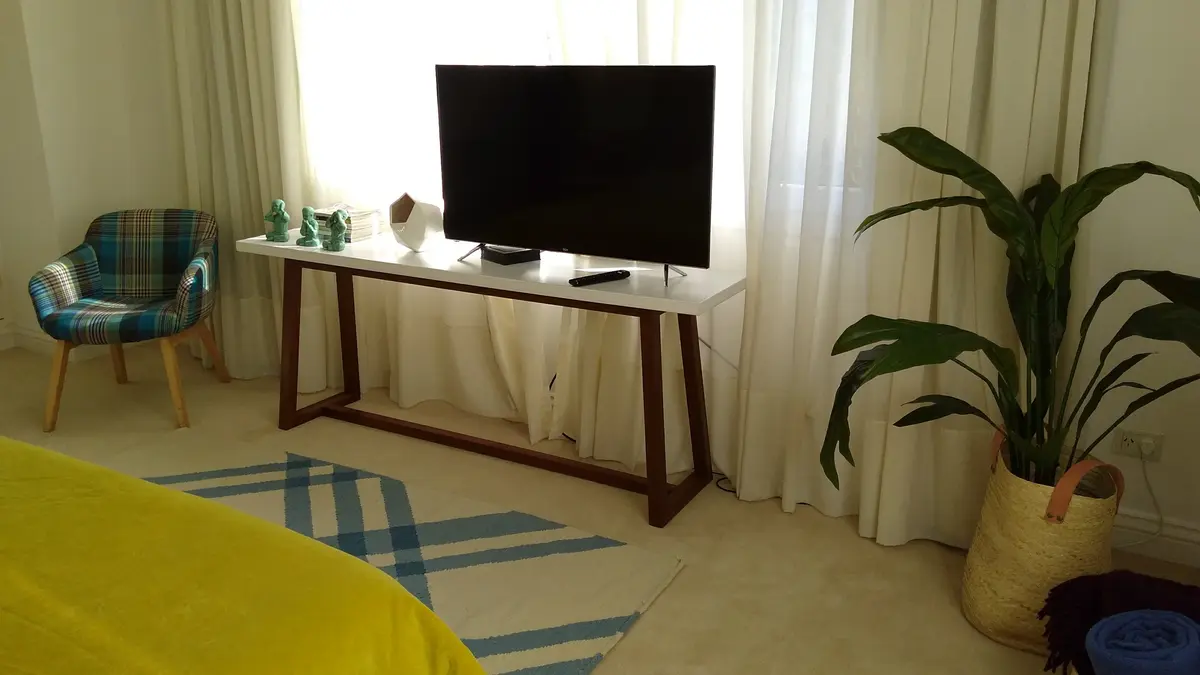 Sala de estar moderna con TV grande y mesa consola — proyecto Casa VG, por Vicky Hurrell, en Mar del Plata