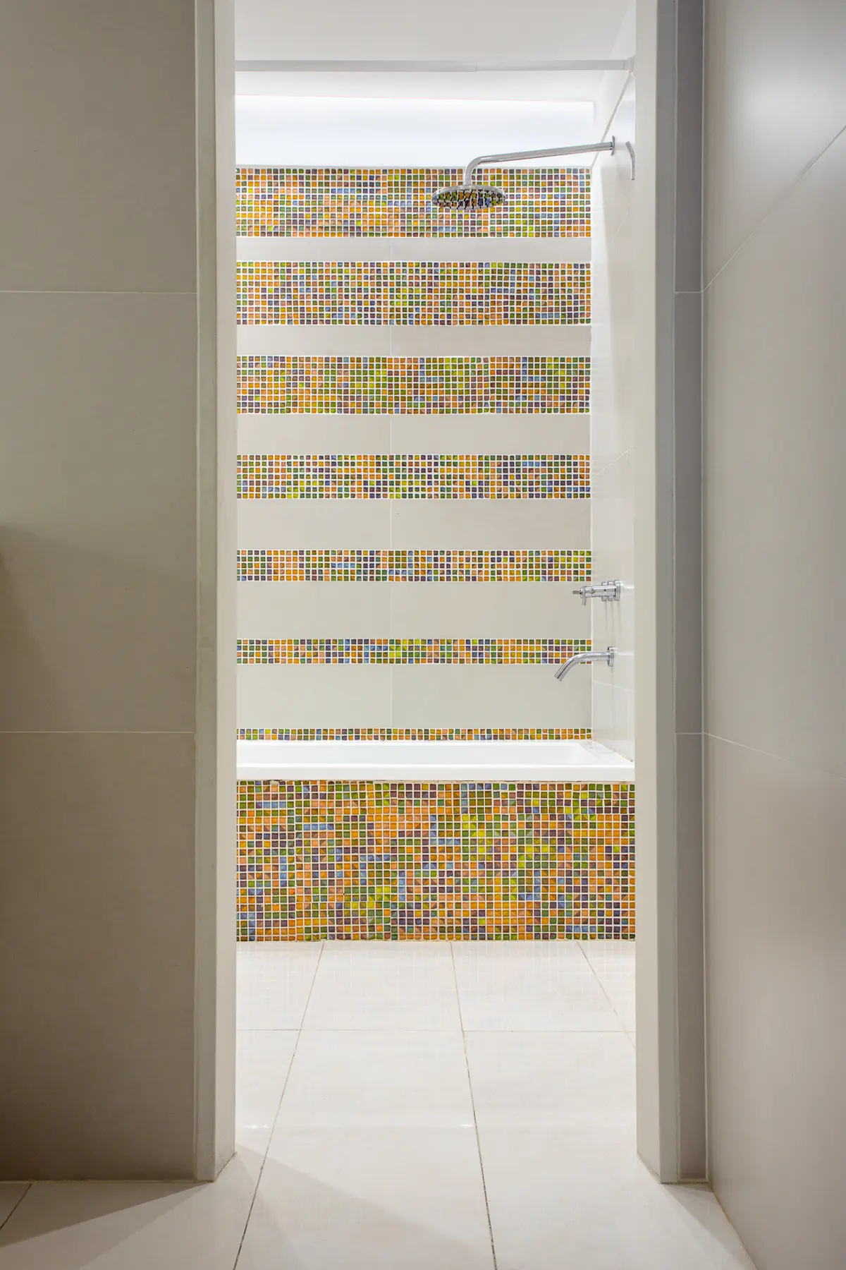 Banheiro moderno com banheira branca e azulejos coloridos — projeto Baño en Belgrano, por MARCO GUOLI PHOTO, em Belgrano