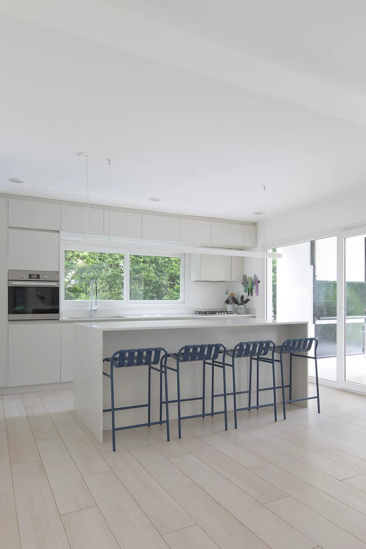 Cozinha moderna escandinava com ilha branca e muita luz — projeto Reforma Isla del Sol, por Estudio YME, em Rincón de Milberg