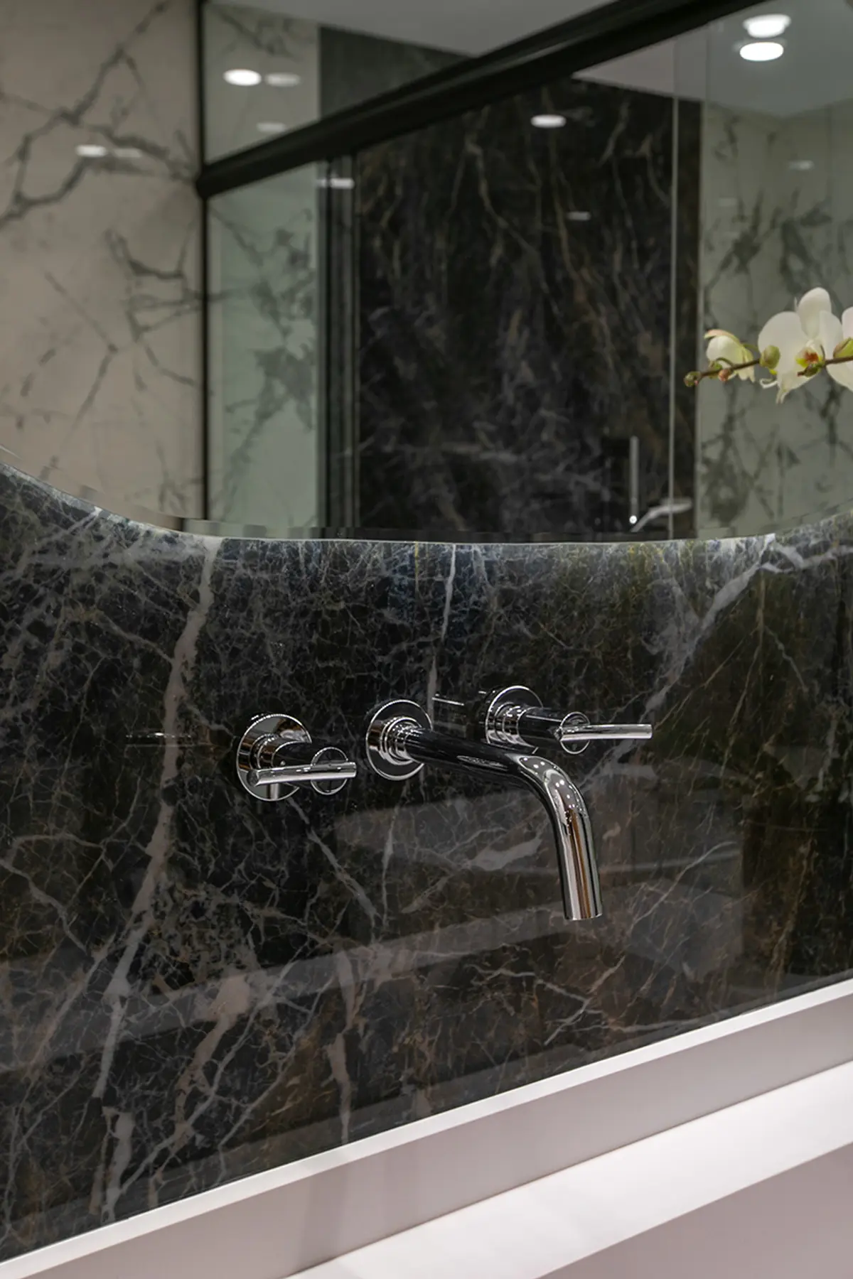 Grifo flotante cromado en pared mármol negro con veta blanca — proyecto Casa Oroño, por Estudio Plats, en Buenos Aires