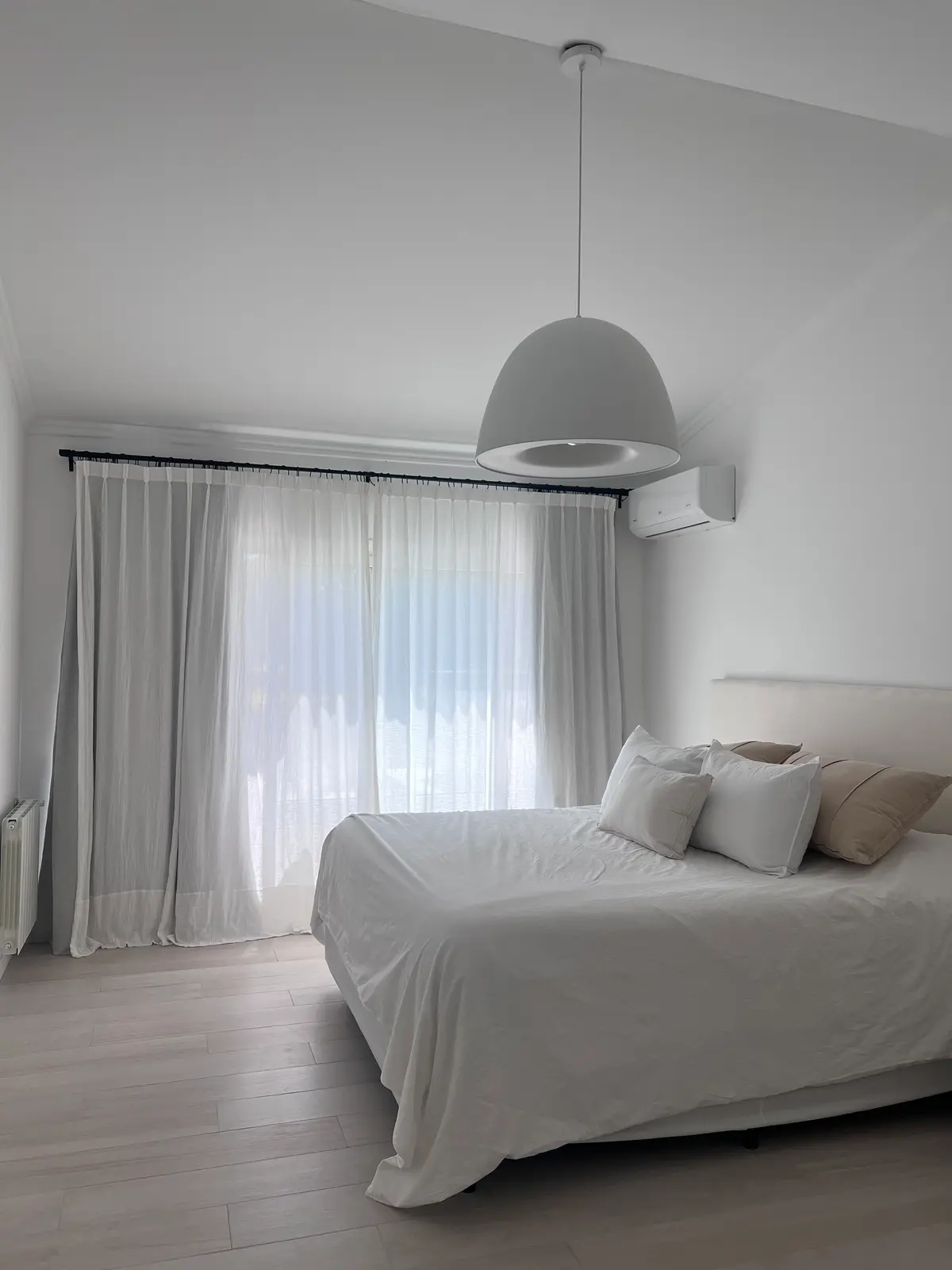 Dormitorio moderno con luz colgante y cortinas blancas — proyecto CASA LA LOMADA , por Estudio Grupo 32, en Pilar