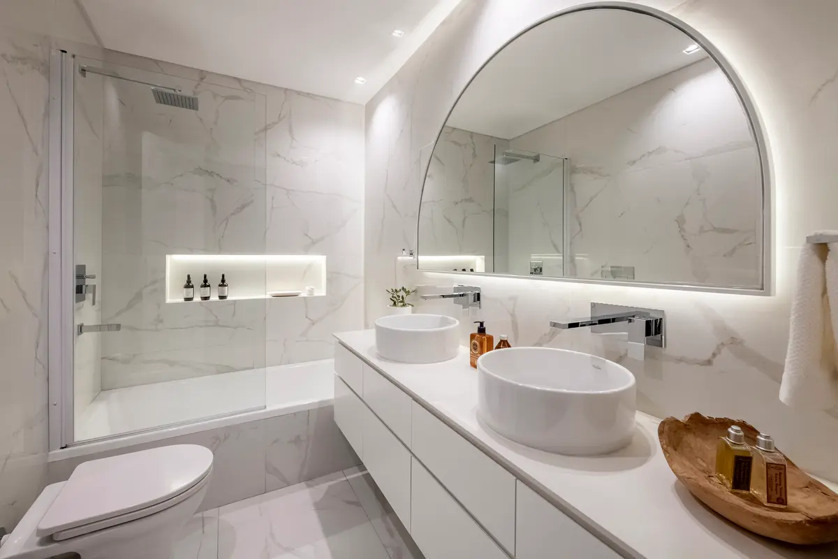 Baño moderno con bañera exenta, espejo curvo y mármol — proyecto AS, por Estudio Basa, en Buenos Aires