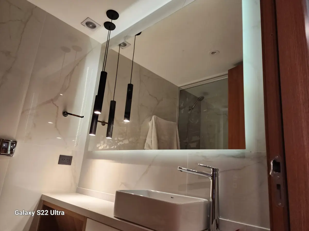 Baño moderno con bacha de loza blanca y luces colgantes negras — proyecto Espejo con bastidor y led, por Cristalcenter, en Recoleta