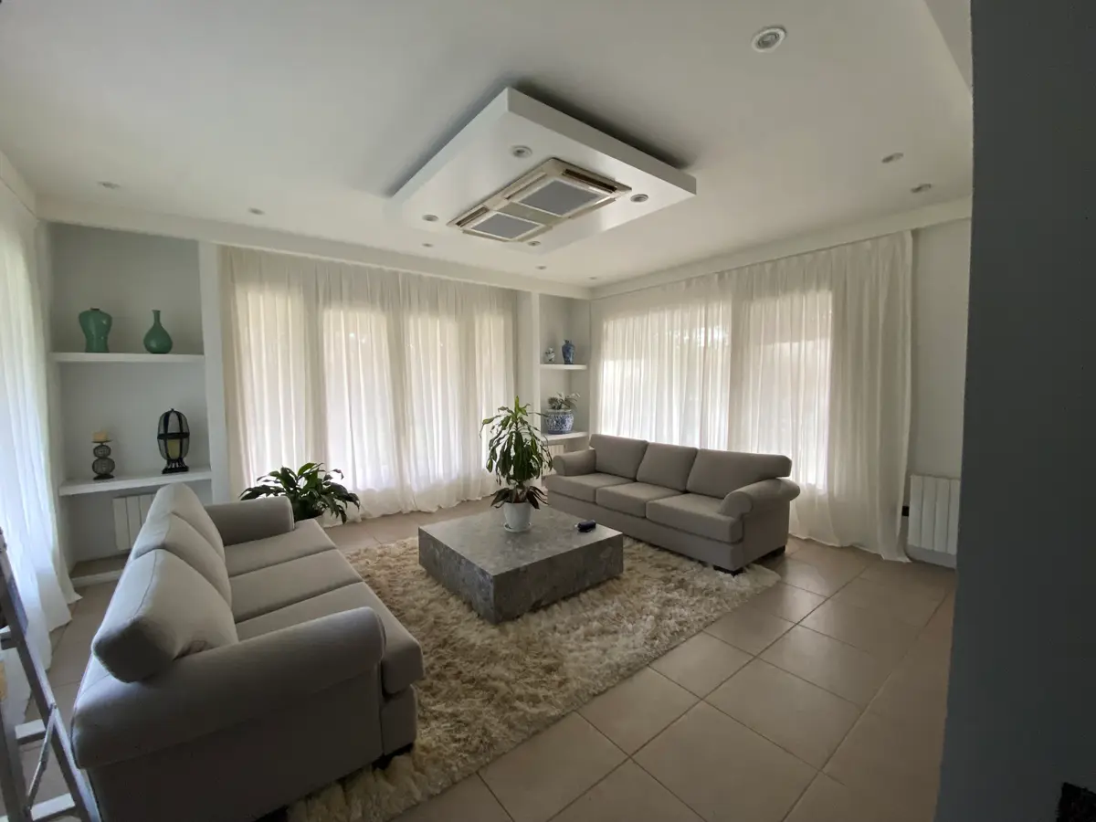 Sala de estar moderna com sofá curvo, tapete felpudo e muita luz natural — projeto Saint Thomas norte, por Vorh, em Canning