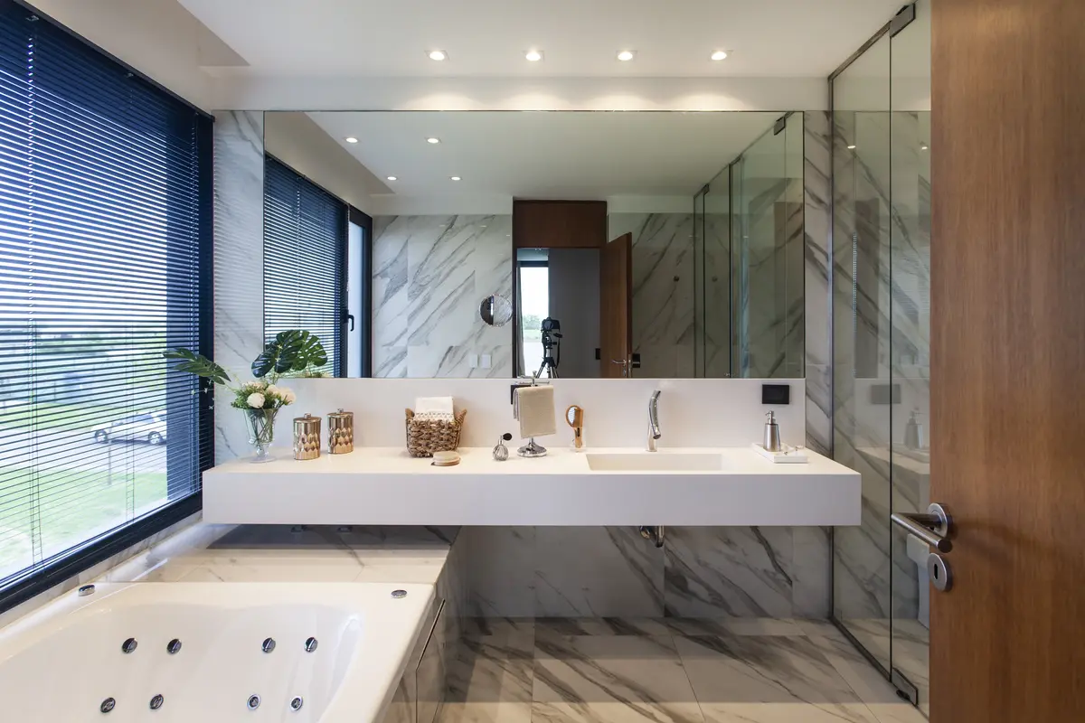 Baño moderno con mesada flotante, mármol y gran espejo — proyecto Casa BJM, por Vanguarda Arquitectos, en Belén de Escobar