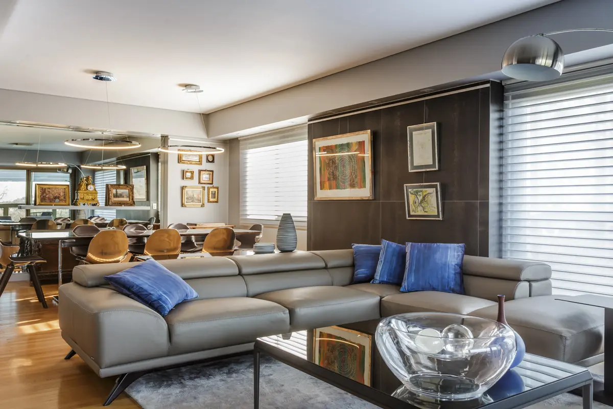 Sala de estar moderna com sofá curvo e detalhes em madeira — projeto Piso en Belgrano, por Gutman+Lehrer Arquitectas, em Belgrano
