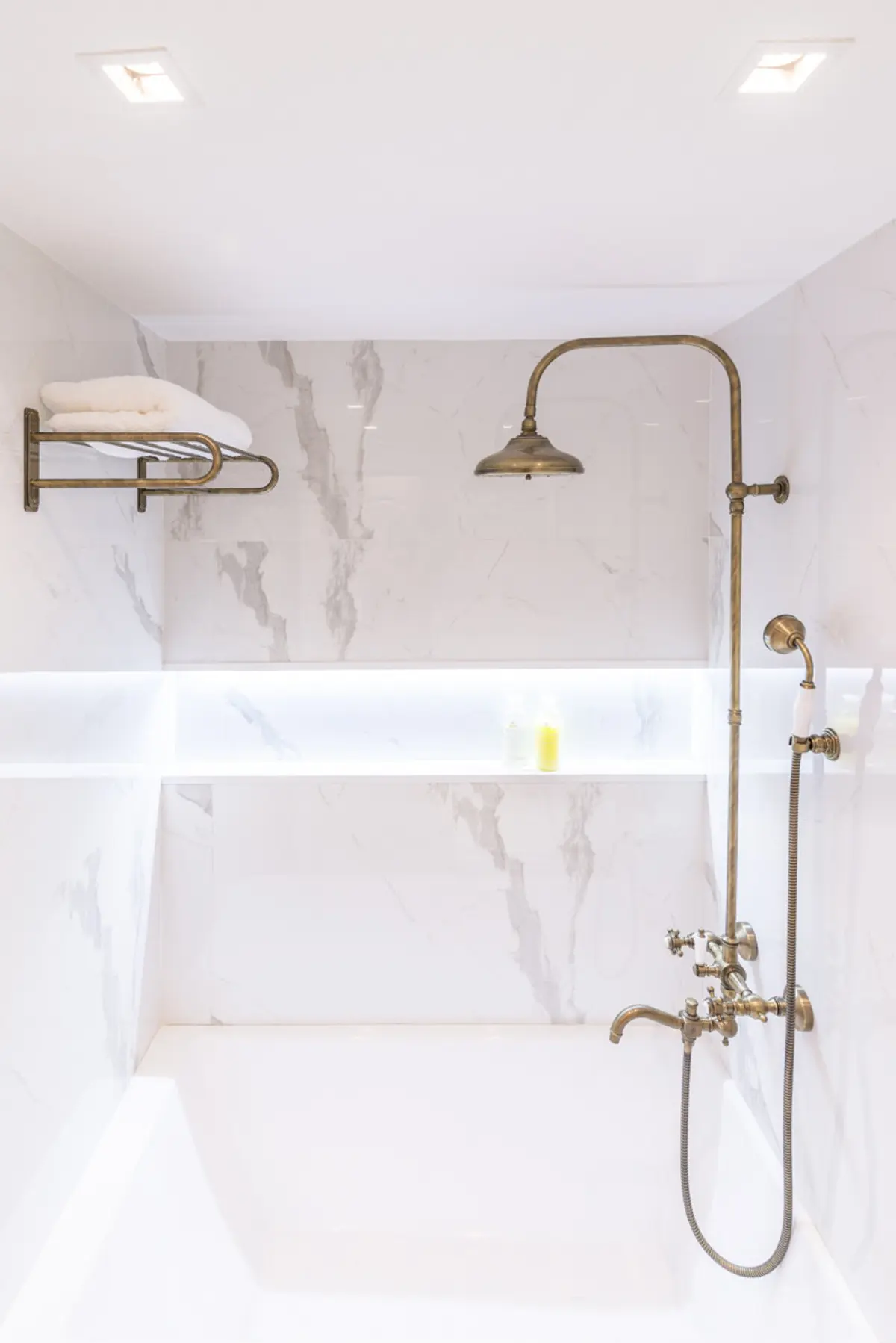 Baño blanco y clásico con ducha de latón antiguo y bañera exenta — proyecto Arce 943, por ST Arquitectas, en CABA