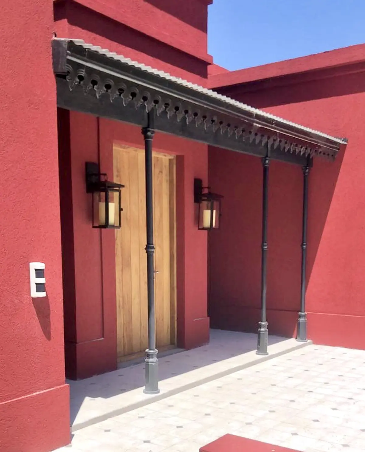 Galeria exterior com lanternas e colunas de ferro preto — projeto Las Vizcachas, por Marconi Silva Arquitectos, em Los Cardales