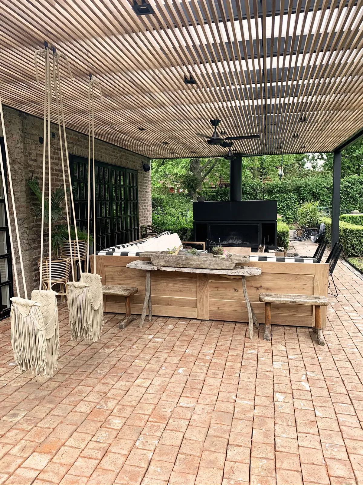 Pérgola curva de madeira e tijolo exposto em pátio exterior rústico — projeto Monroe - La Horqueta, por Mgc.arq, em La Horqueta