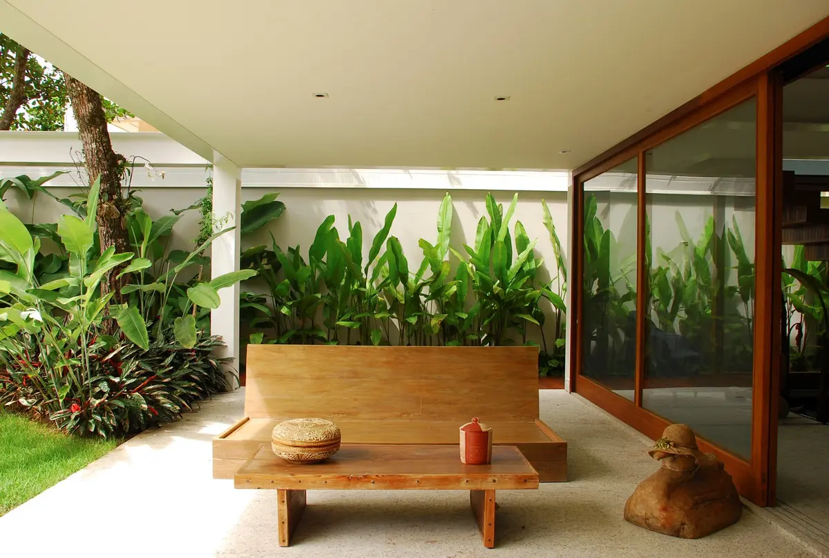 Patio cubierto con bancos de madera y jardin vertical integrado — proyecto Residência MI, por Gil Fialho