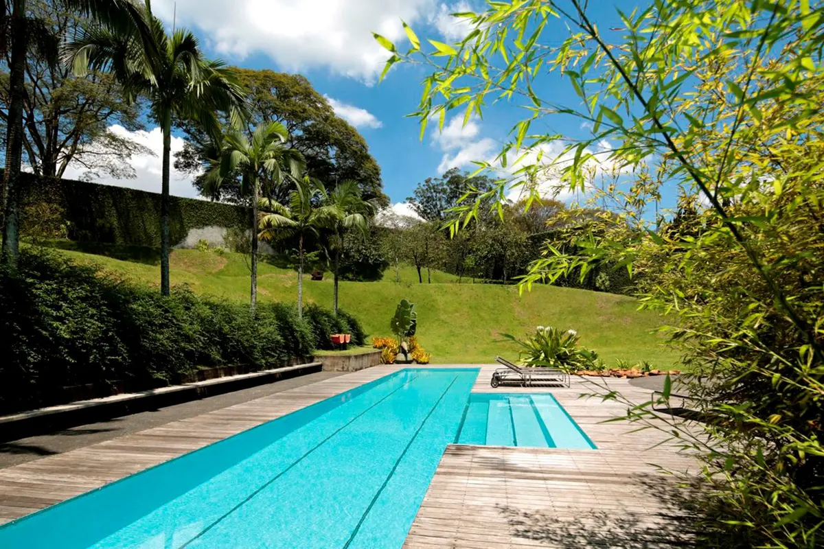 Pileta lap pool de estilo moderno con deck de madera y jardín verde — proyecto Residência PU , por Gil Fialho