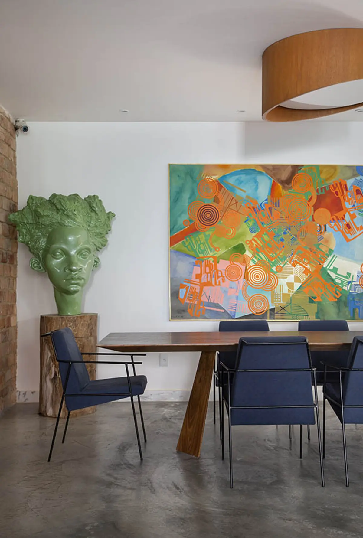 Comedor contemporáneo con mesa madera, sillas azules y arte colorido — proyecto Casa Jardim Guanabara, por Amanda Miranda
