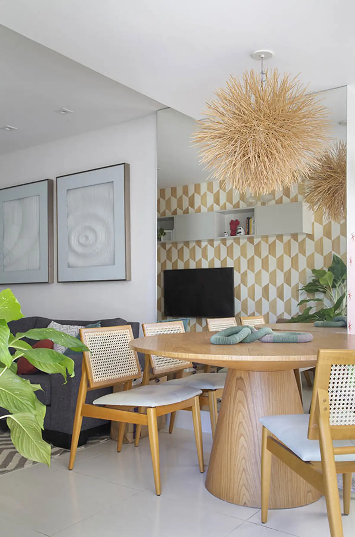 Comedor moderno boho con mesa redonda de madera y sillas de caña — proyecto Cobertura Arquiteta, por Amanda Miranda