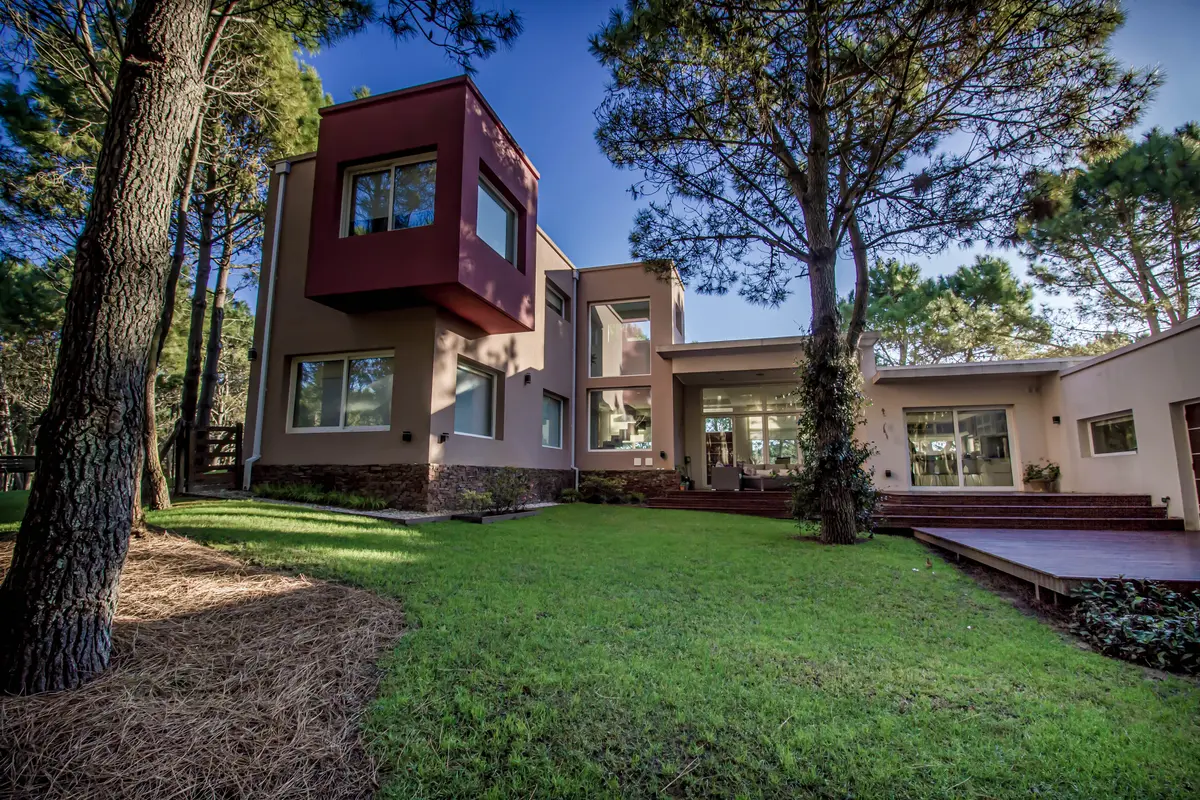 Fachada moderna com volume vermelho e grandes janelas — projeto Vivienda Unifamiliar en Pinamar, por Estudio Schifano, em Pinamar