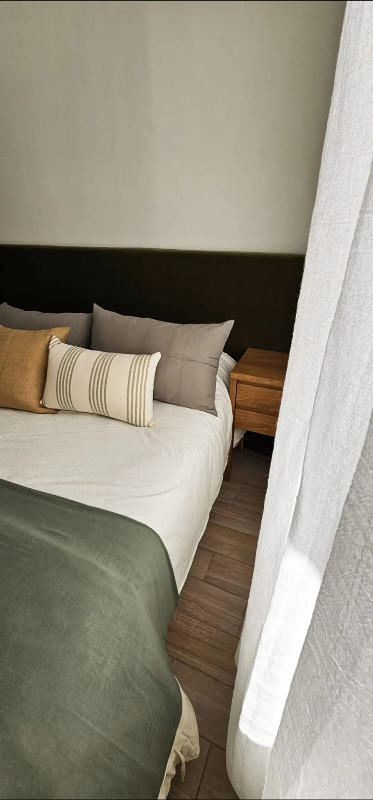 Quarto moderno com têxteis naturais e piso de madeira escura — projeto Callao, por Claraboia, em Recoleta