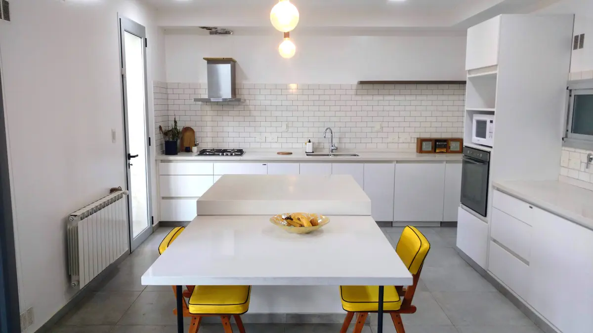 Cocina moderna con isla central, sillas amarillas y azulejos blancos — proyecto cocina, por Tu Mueble, muebles a medida, en Gonnet