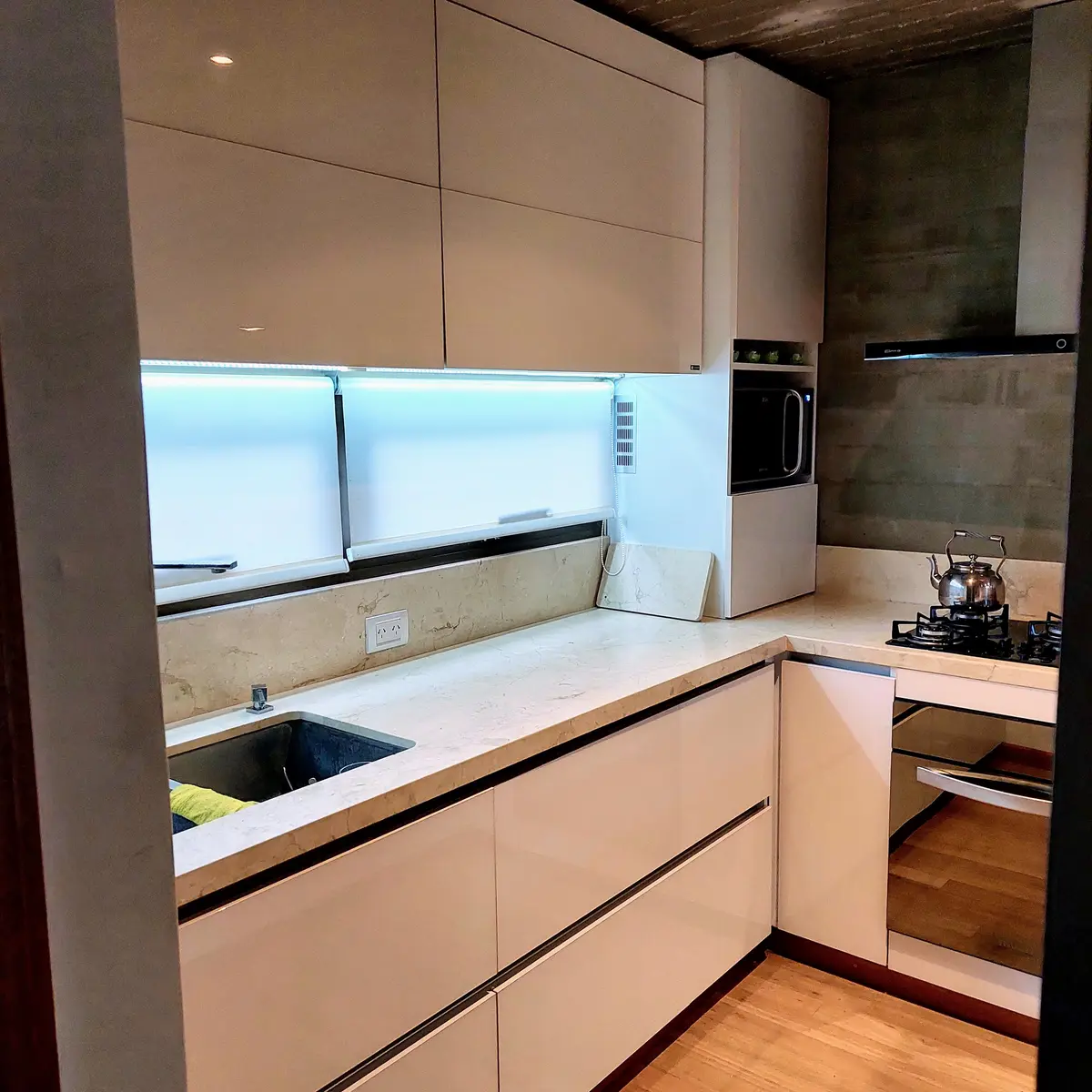 Cocina moderna minimalista con gabinetes blancos y mesada de mármol claro — proyecto Cocina pequeña, por Tu Mueble, muebles a medida, en Gonnet