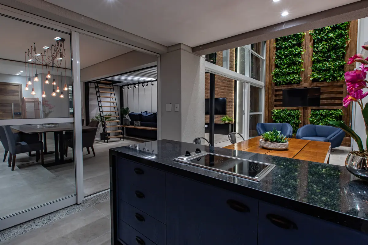 Cocina moderna con isla de marmol negro y jardin vertical integrado — proyecto Duo Morumbi, por Pricila Dalzochio