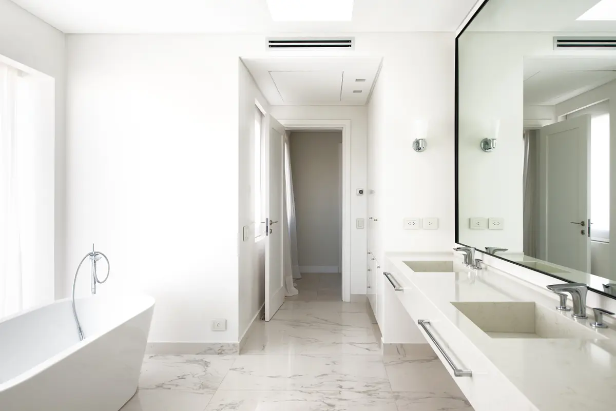 Banheiro moderno e iluminado com banheira de imersão e bancada dupla — projeto Casa DF, por Estudio Junor, em Tigre