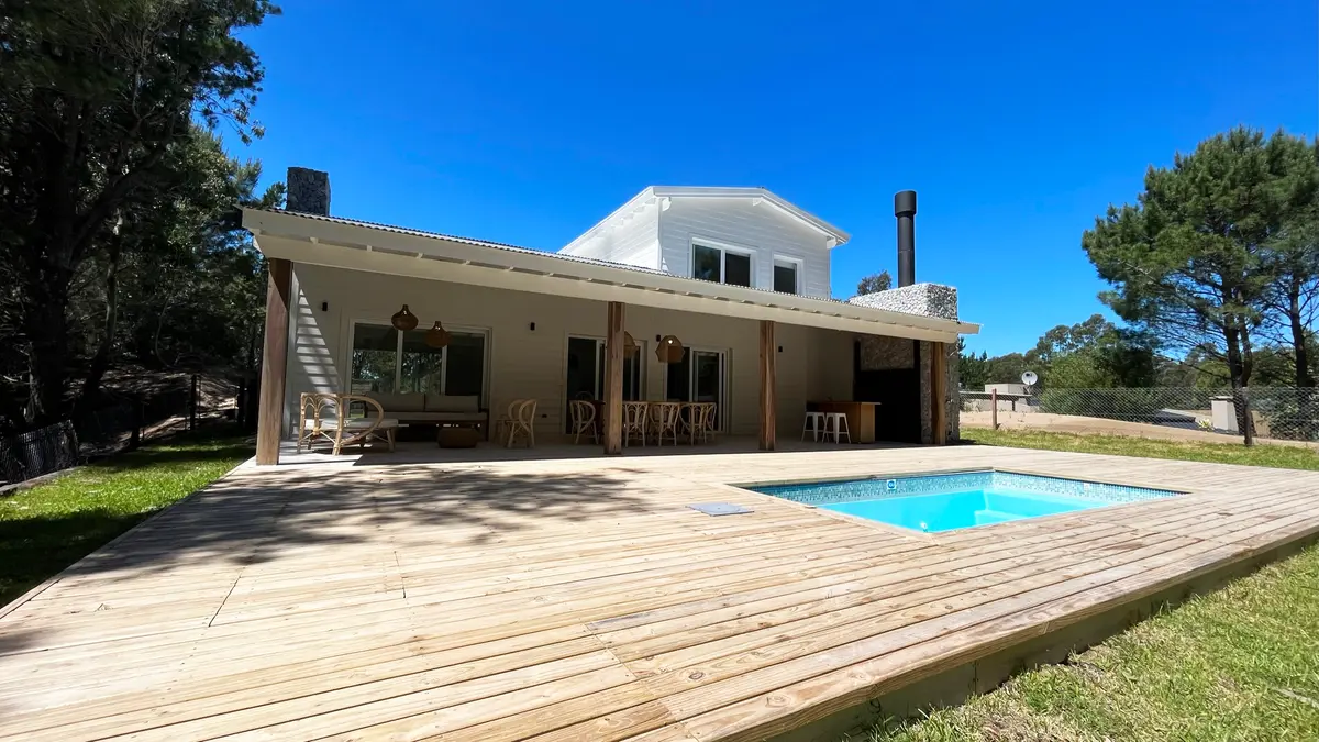 Casa moderna com deck de madeira e piscina cercada por natureza — projeto Casa Luvir - Barrio Costa Esmeralda (Partido de la Costa, Buenos Aires) German S, por German Salas arquite