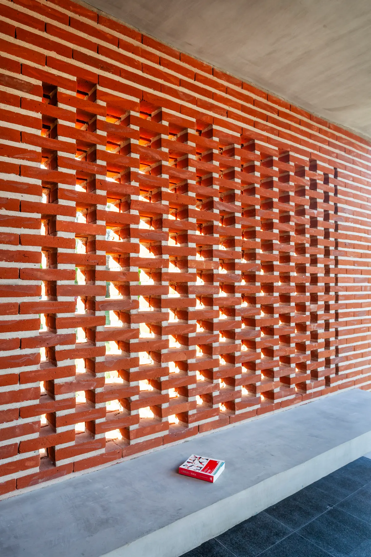 fachada moderna com parede de tijolos aparentes e banco de concreto — projeto Casa FLOIG, por V2 Arquitectos, em Villa Elisa