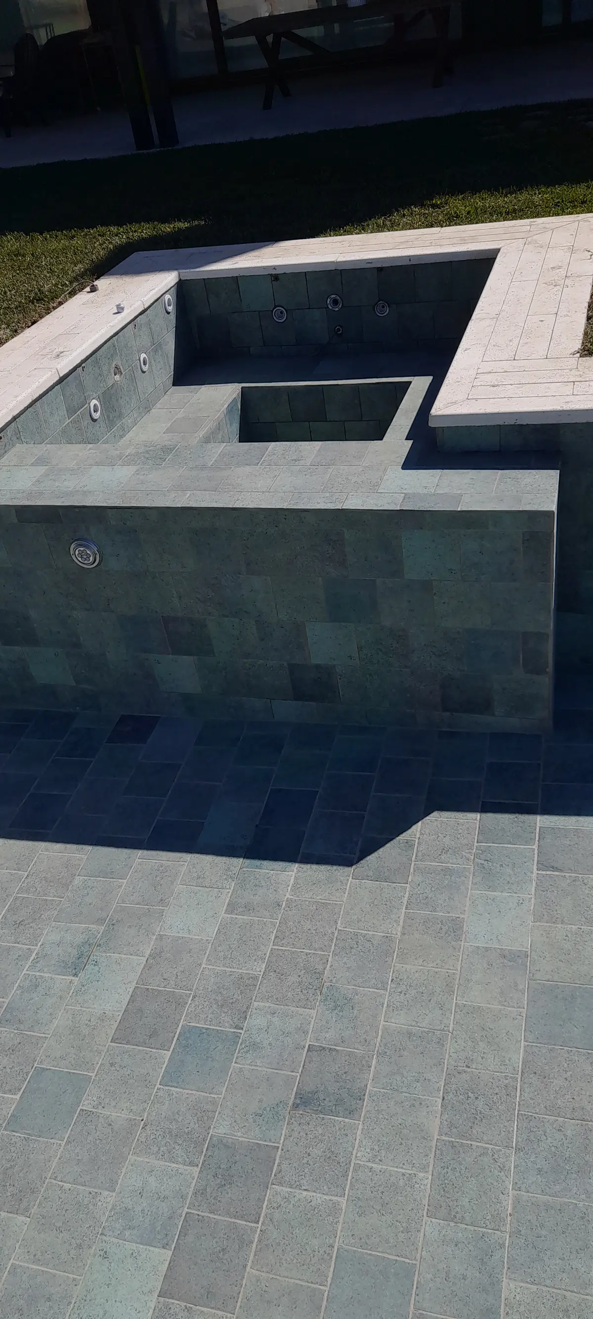 pileta moderna con bordes hormigon y deck de piedra gris — proyecto piscina con hidromasaje, por Piscinas omar, en San Isidro