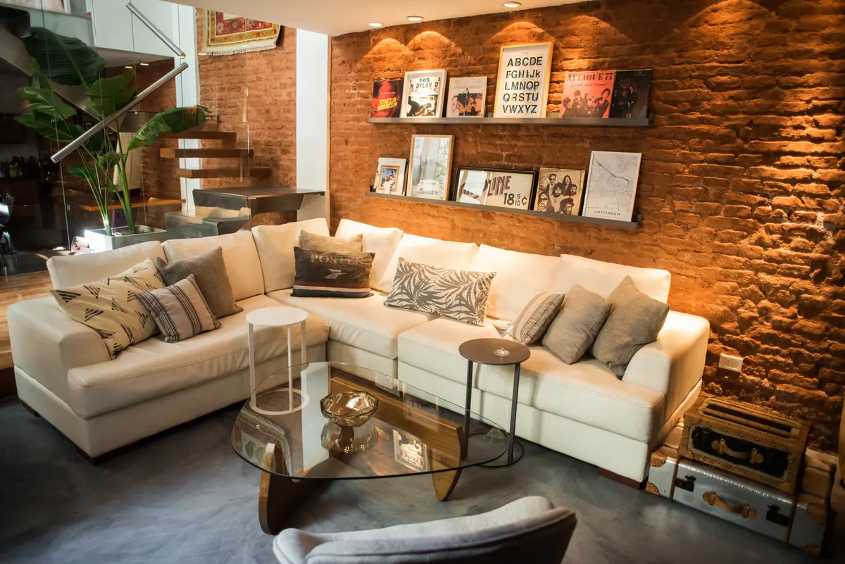 Sala moderna com tijolo aparente e sofá modular — projeto Defensa, por Estudio Basa, em CABA