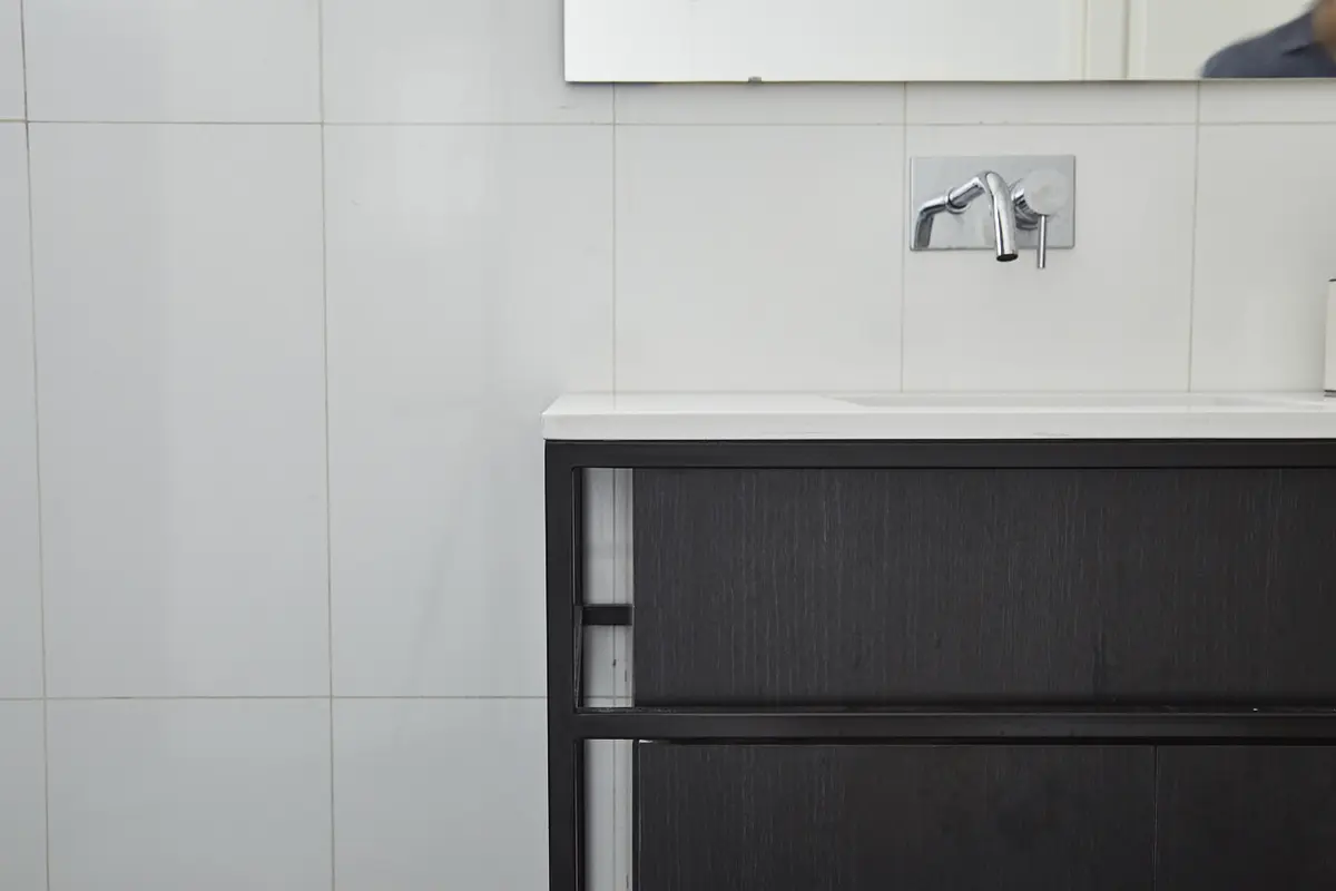 bano moderno con mueble de madera oscura y griferia cromada — proyecto BERUTI 2, por Estudio Trama, en Palermo