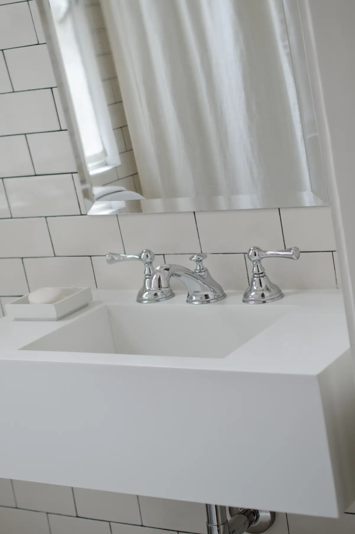 Banheiro moderno com pia branca, torneira cromada e azulejos brancos — projeto Dpto LH, por Estudio Dado, em Recoleta