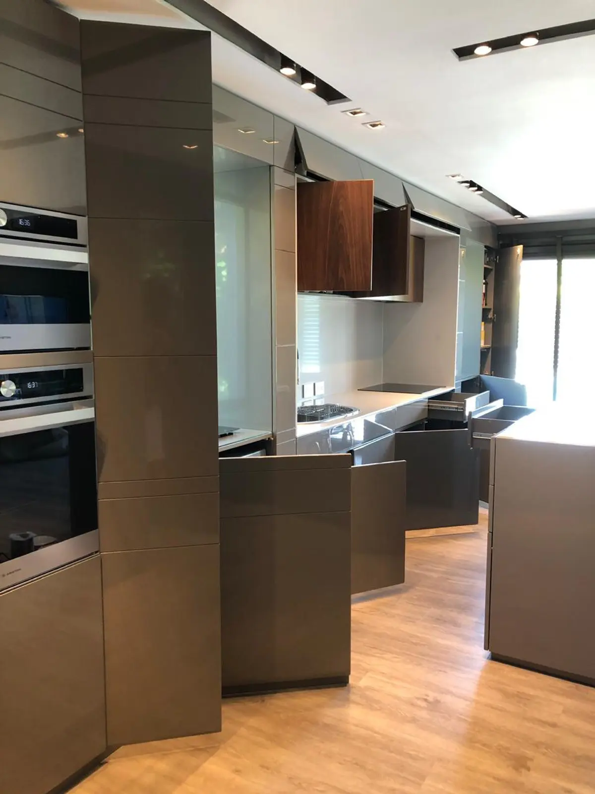 Cozinha moderna minimalista com armários cinza e madeira — projeto Casa Nordelta, por Etude Interiorismo, em Nordelta
