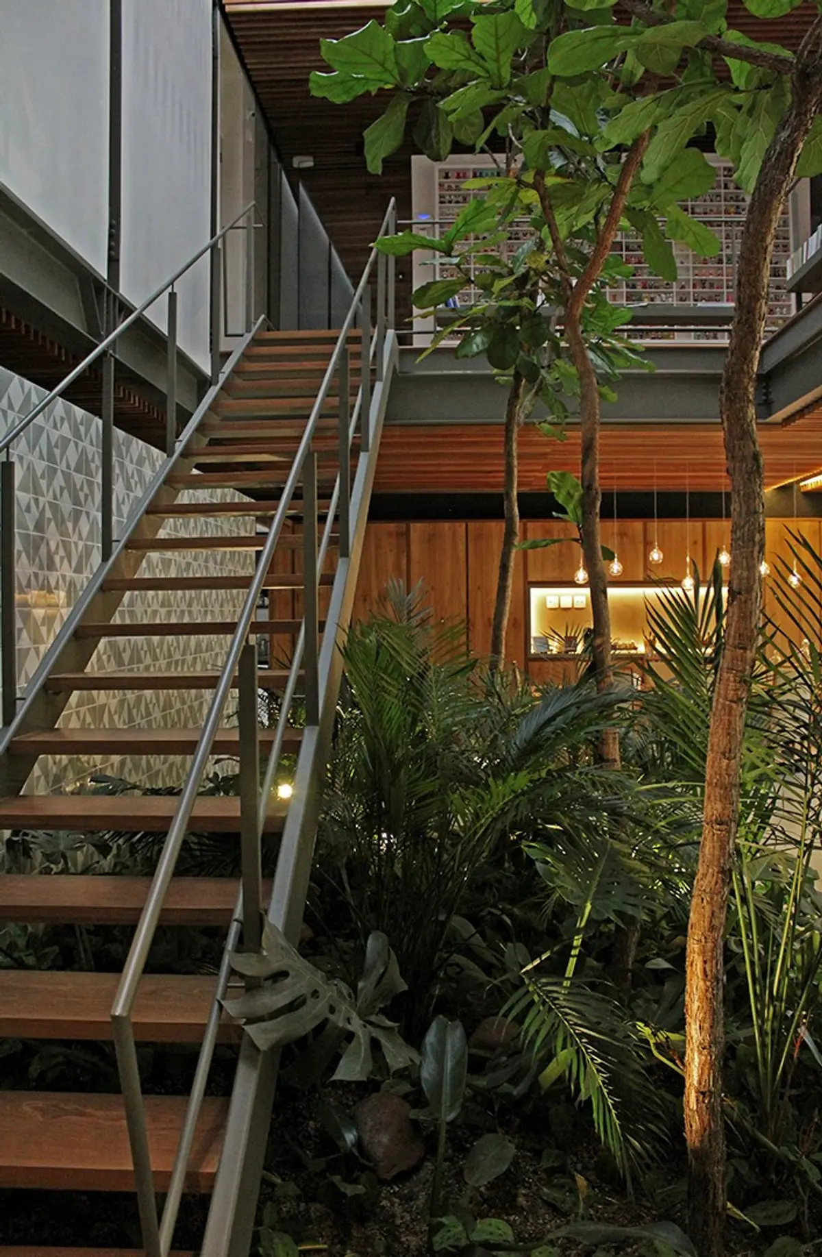 Escalera metal y madera con plantas en doble altura moderna — proyecto Residência MC, por Gil Fialho