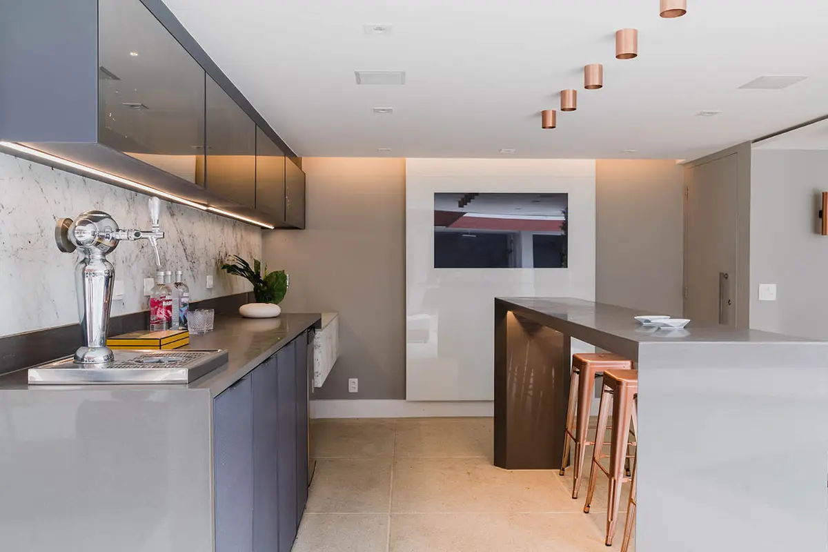 Cocina moderna con isla central, mesadas mármol y cálida iluminación empotrada — proyecto Casa Barra ED, por Amanda Miranda