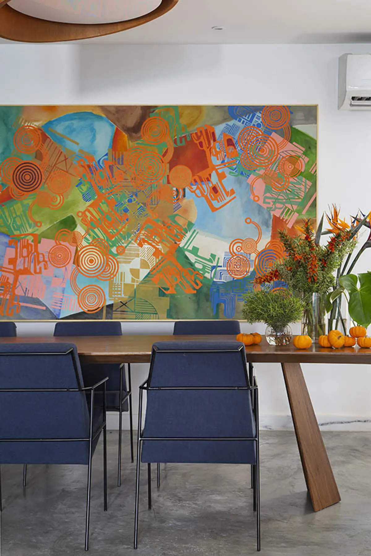 Comedor moderno con mesa madera, sillas azules y mural abstracto colorido — proyecto Casa Jardim Guanabara, por Amanda Miranda
