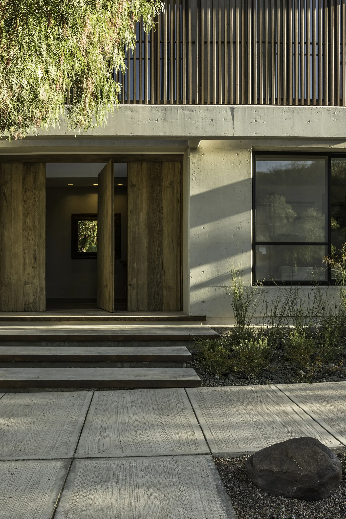 Fachada contemporánea con entrada de madera y hormigón visto