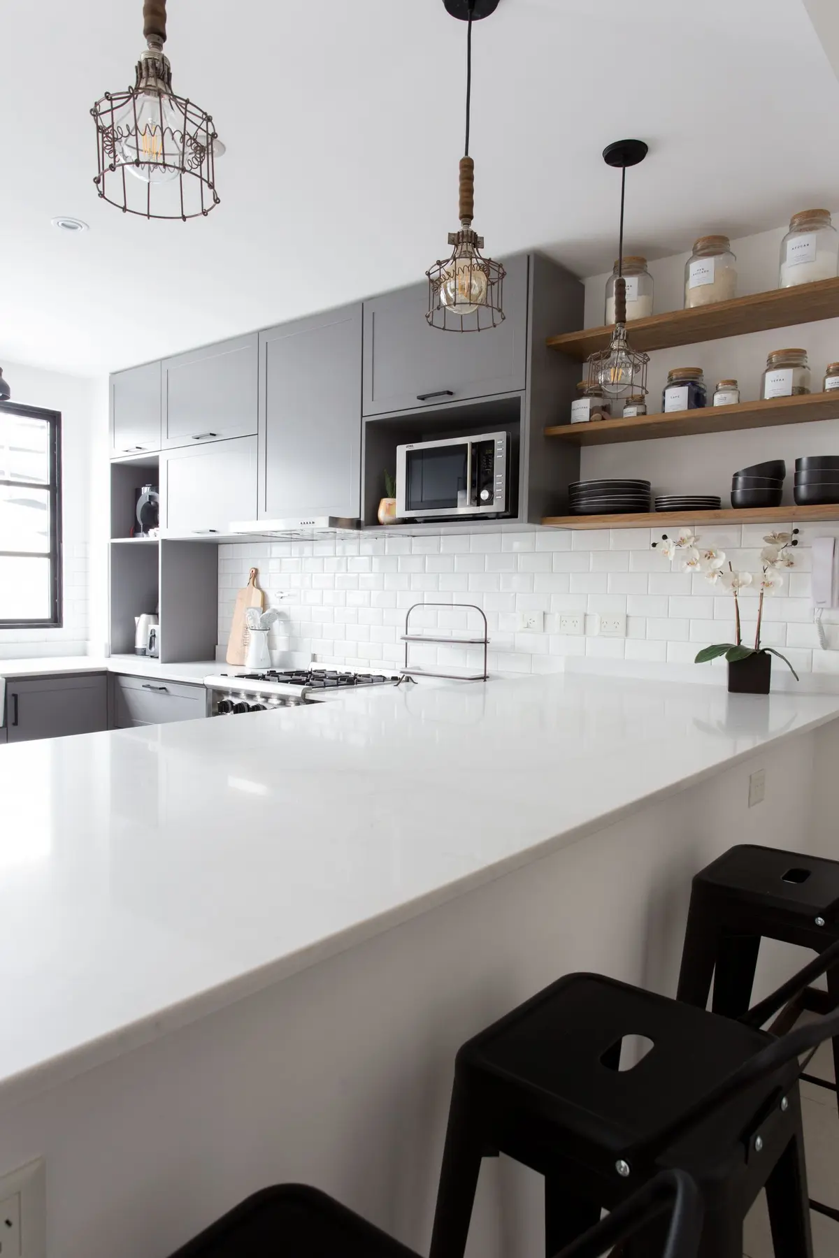 Cocina moderna con isla blanca, mesadas de mármol y estantes de madera — proyecto Obra Olazábal II, por SYA Arquitectas, en Belgrano