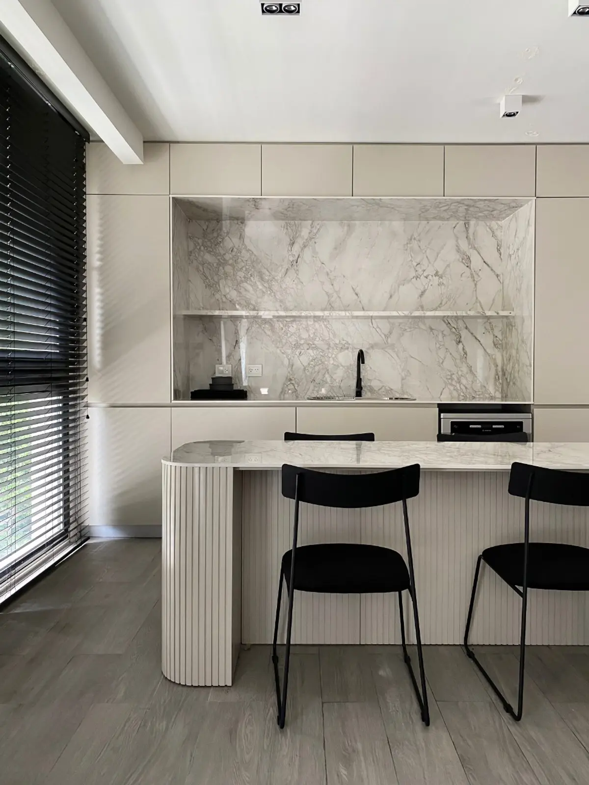 Cocina moderna con isla de mármol, detalles acanalados y luz natural — proyecto Pampa, por ABEJA CONCEPT, en Belgrano